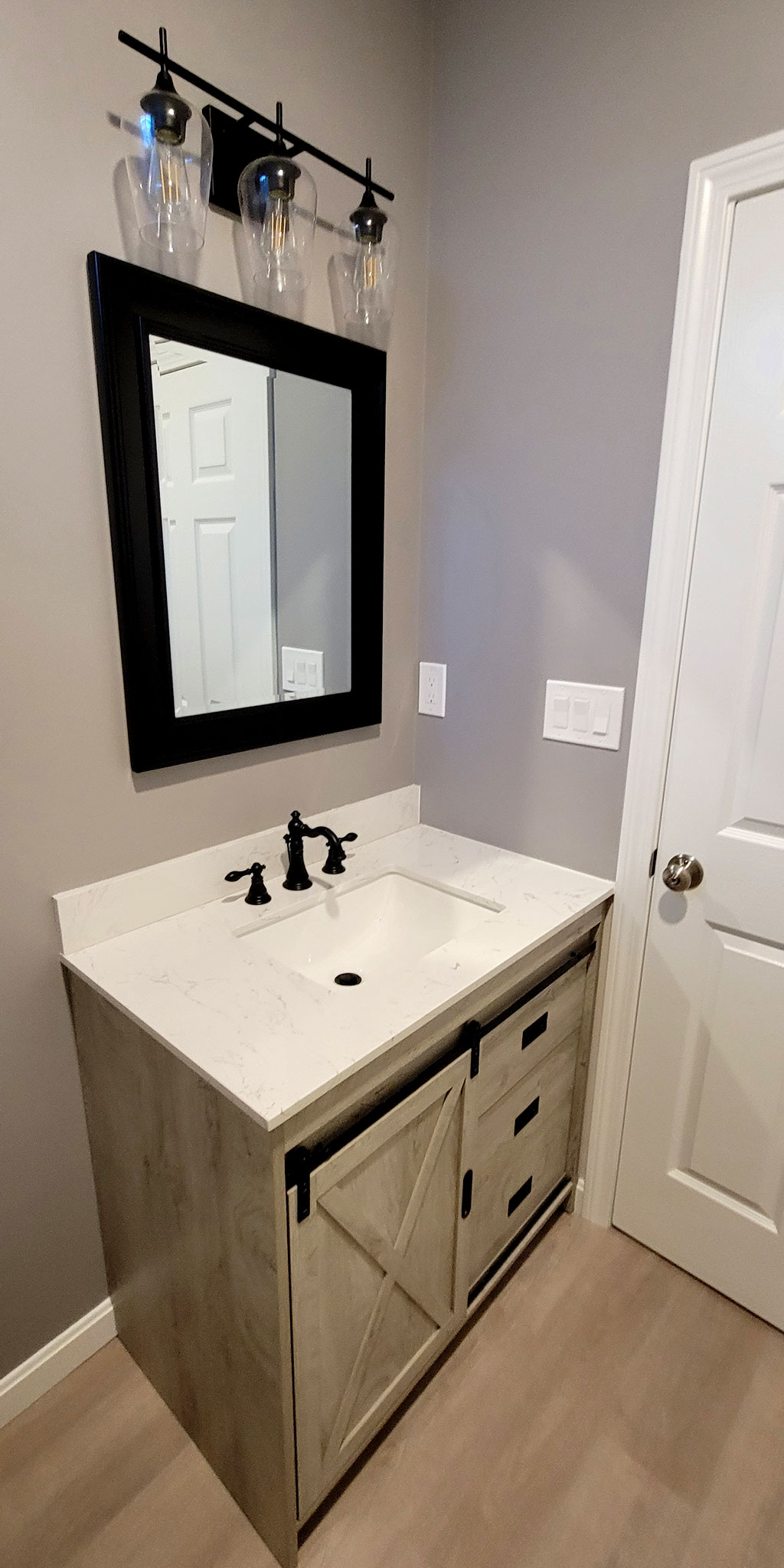 A picture of the new vanity, mirror and vanity light fixture.